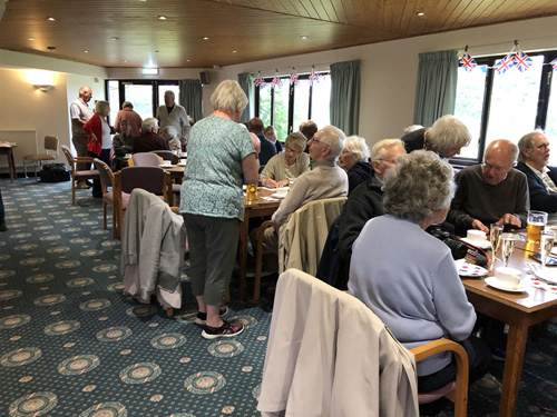 Picture taken of the whole room with people sitting at tables