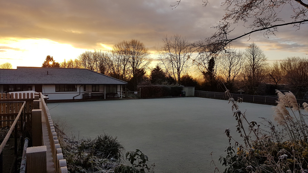 The green covered in frost. Picture taken from the path behind Gladstone Village Hall.