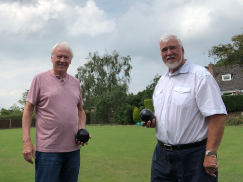 Brian & Mike pose on the green, each holding one wood.