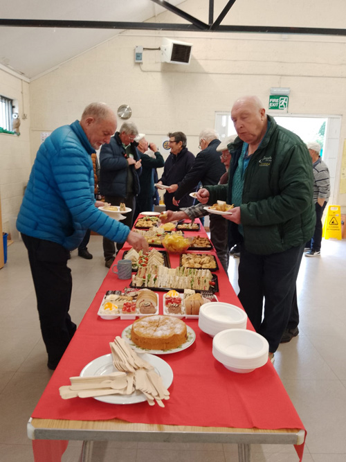 Bowlers choosing food from the buffet table