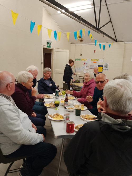 Bowlers from Burton & Puddington at a table eating sandwiches, crisps etc