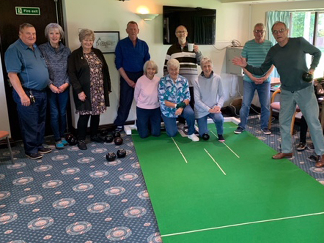 Group of bowlers posing at the end of the mat.