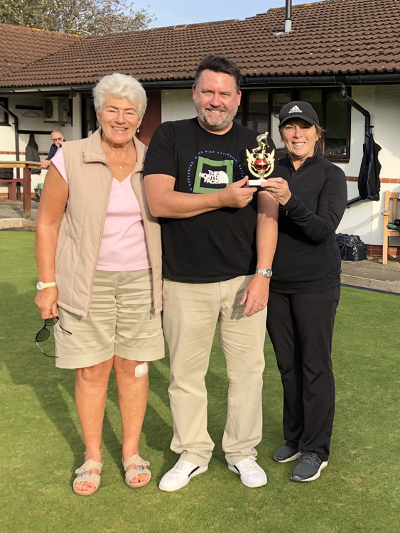 Pat presented the trophy to Mark and Thora and all three pose on the green.