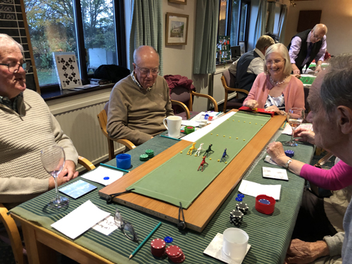 Pat K, Geoff, Liz, Kath and Rod at the Escalado table. A race is in progress and everyone is watching carefully.