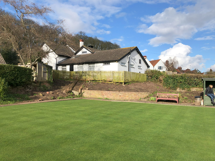 Picture of the bowling green facing Gladstone Village Hall. Area cleared of weeds and foliage.