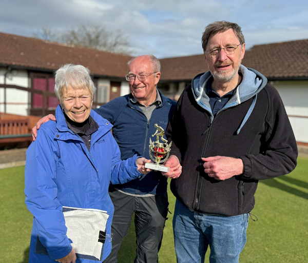 Sandra presents the trophy to Geoff and Geoff.