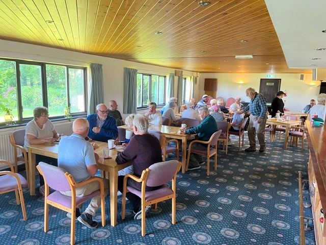 View of Clubhouse with players sitting at tables with cake and drinks