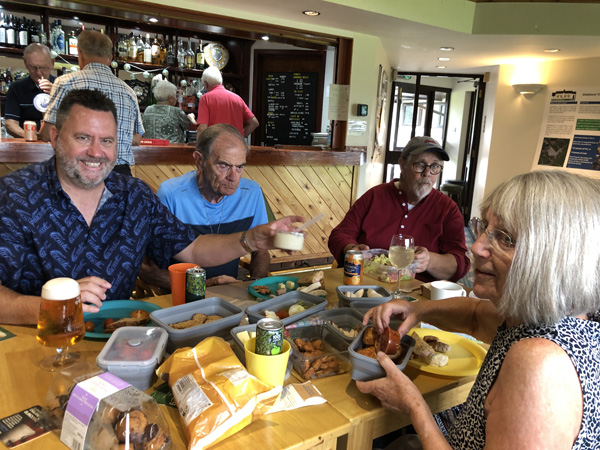 Members at the long table with picnic food