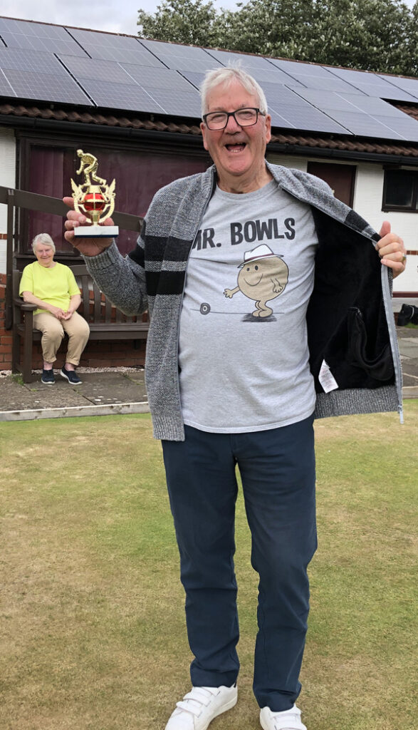 Poses with the trophy and show off his Mr Bowls t-shirt. His partner, John, declined to be photographed!