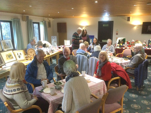 People sitting at tables with drinks and cake