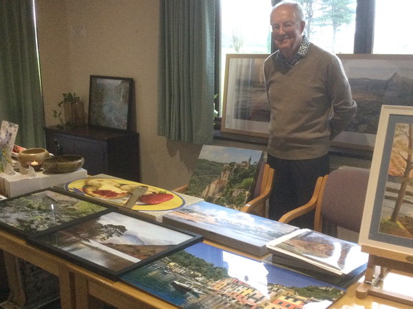 Geoff standing behind a table with his photographs.