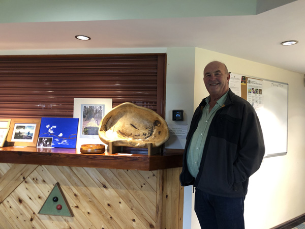 Bob standing in front of the bar and his large wooden bowl.